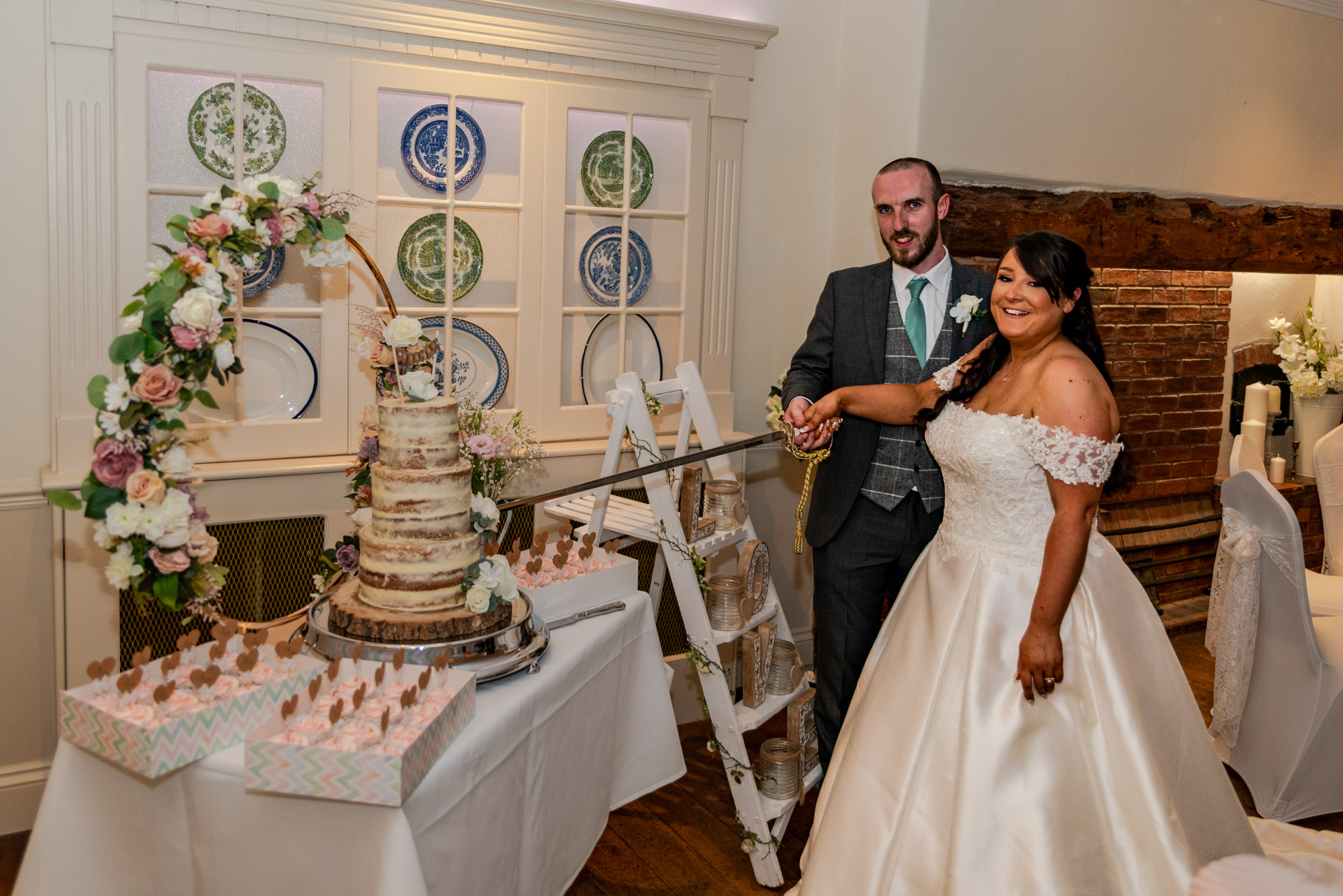 Bride and Groom cake cutting with a military sword at The Barns Hotel Cannock